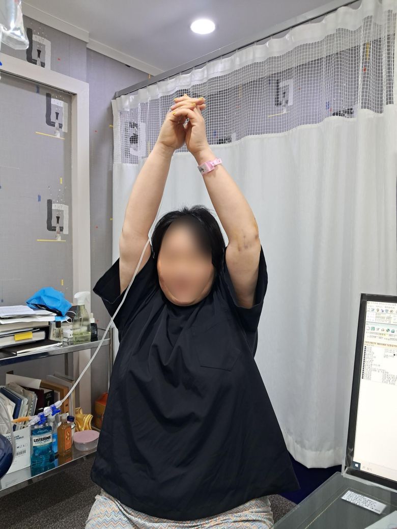 이건목원리한방병원에서 오십견 치료를 받은 신 모(여·54) 씨가 도침과 원리 침술 시술 후 움직이기 어렵던 팔을 들어 올려 보고 있다.