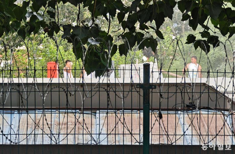 지난달 30일 중국 베이징의 주중국 북한대사관 모습. 철조망 너머로 공사 중인 인부들이 땀을 닦고 있다.  베이징=김철중 특파원 tnf@donga.com