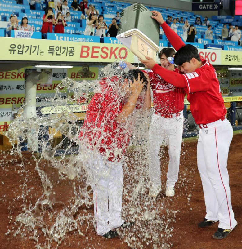 노경은(왼쪽)이 11일 삼성전에서 프로야구 최초 3년 연속 30홀드 기록을 달성한 뒤 물세례를 받고 있다. SSG 제공