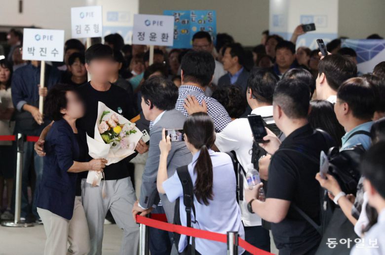 12일 인천국제공항 제2터미널 장기 주차장에서 한 근로자가 가족들로부터 꽃다발을 받고 있다. 인천=박형기 기자 oneshot@donga.com