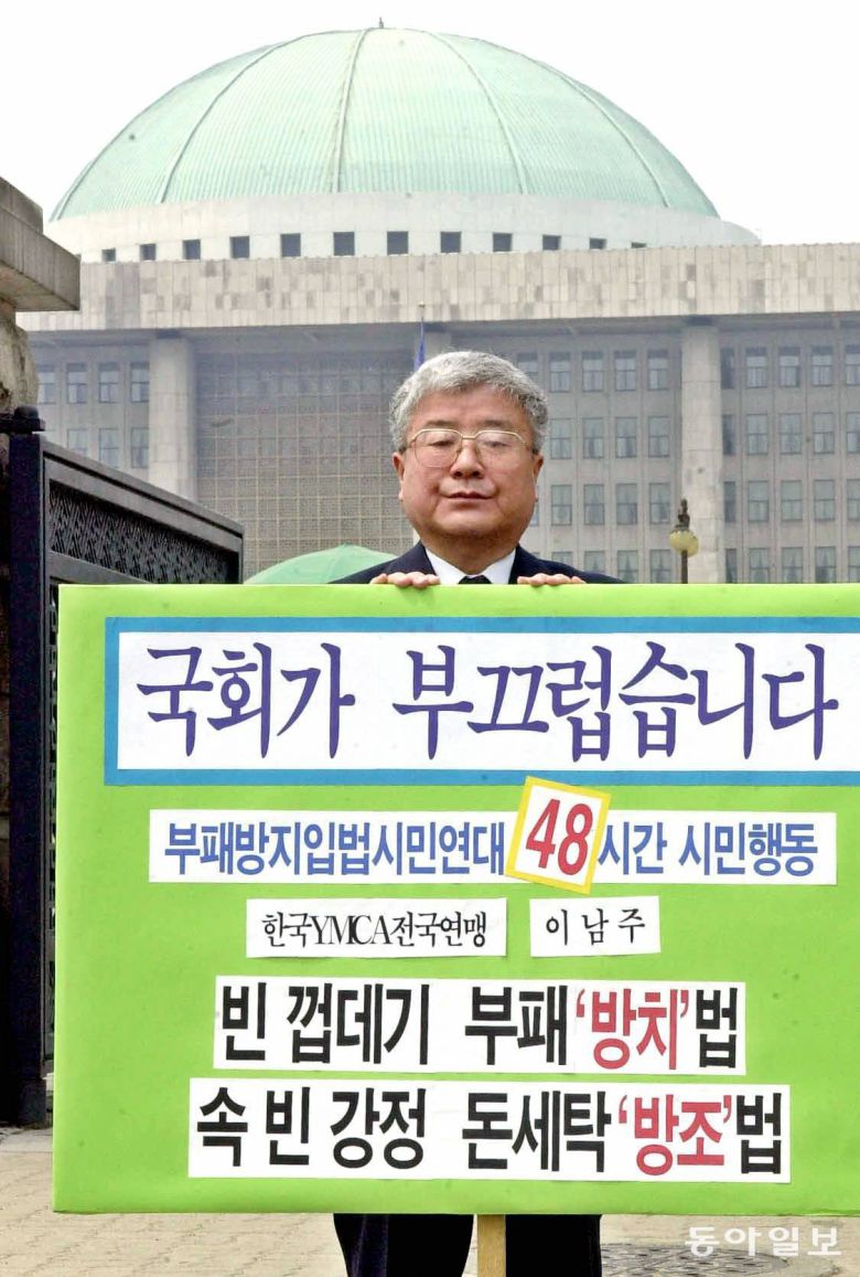 부패방지입법시민연대 소속 이남주 한국YMCA전국연맹 사무총장이 국회앞에서 `빈껍데기 부패방치법 속빈강정 돈세탁 방조법`이란 피켓으로 48시간동안 철야로 릴레이 1인시위를 벌이고있다./2001년 4월 25일.동아일보 DB.