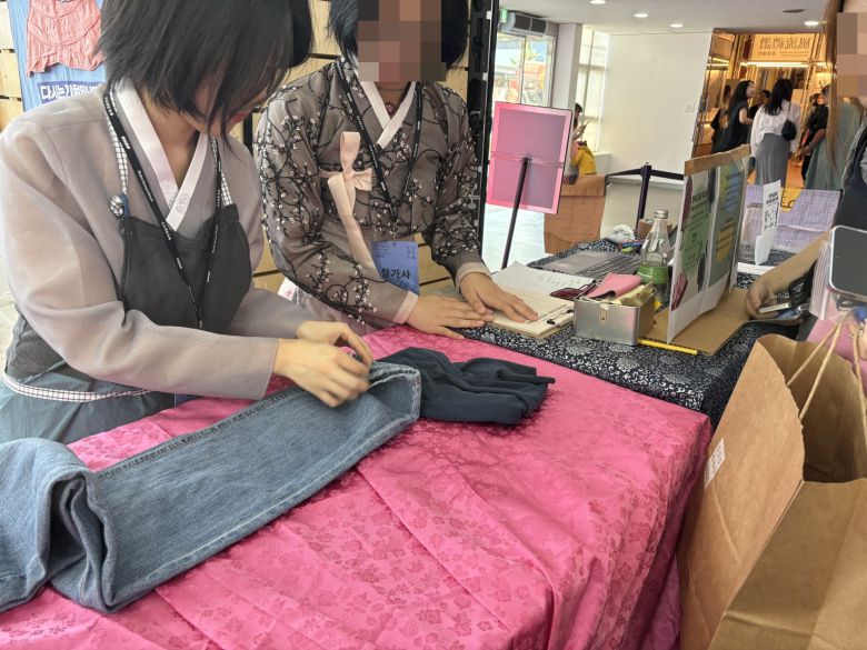 헌 옷을 가져오면 한복이나 전통 소품으로 교환해 주는 ‘리사이클링 한복 교환전’. 한 시민이 안 입는 바지를 기부하고 있다. 사진=김승현 기자 tmdgus@donga.com