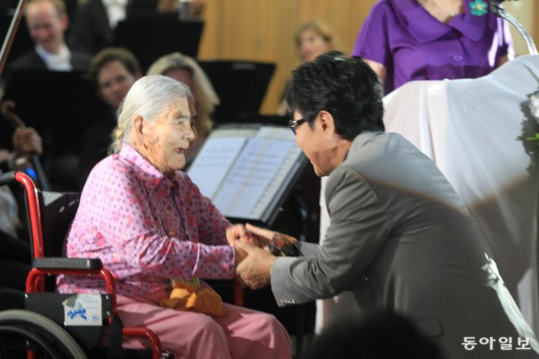 2011년 5월 5일 5일 세계적 명성을 얻고 있는 영국 ‘필하모니아 오케스트라’단과 국민가수 조용필씨가 전남 고흥군 소록도를 찾아 한센인들을 위한 연주회를 가졌다. 가수 조용필 씨가 한센인 할머니의 손을 잡고 있다. 박영철 기자.