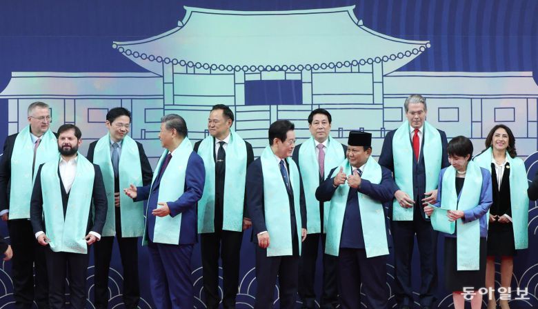 이재명 대통령이 1일 경북 경주화백컨벤션센터에서 APEC 정상회의에 참석한 각국 정상들과 전통한복 목도리를 하고 단체 기념촬영을 준비하고 있다. 목도리에는 APEC 정상회의 엠블럼과 한글 자음 모음이 금박으로 새겨져 있다. 경주=송은석 기자 silverstone@donga.com