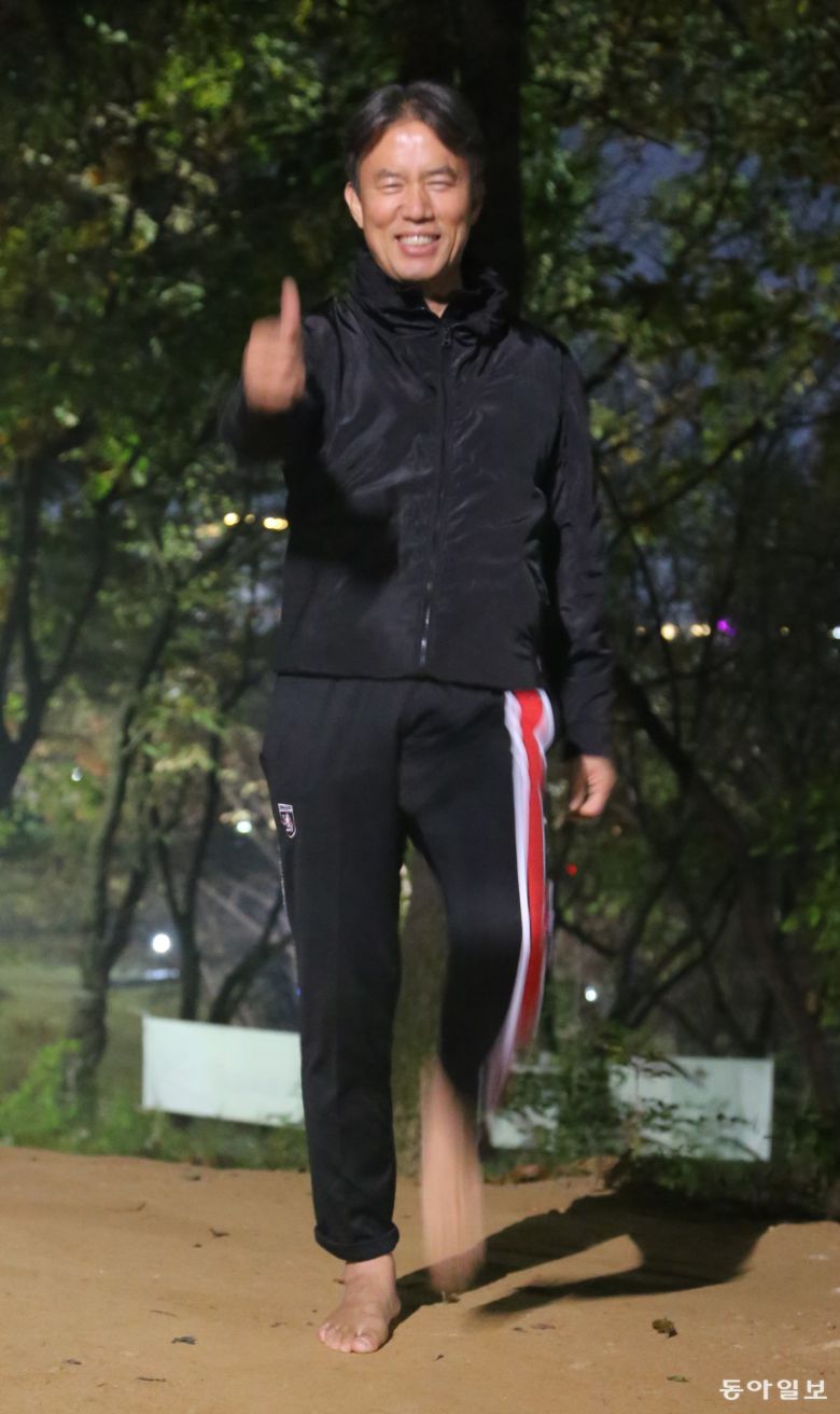 박경운 경감이 밤에 집 근처인 경기 파주 운정호수공원에서 맨발 걷기를 하며 엄지척하고 있다. 파주=양종구 기자 yjongk@donga.com