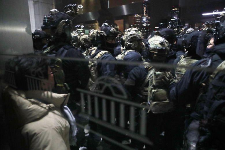 지난해 12월 4일 계엄군이 서울 여의도 국회 본청 앞에서 경내로 진입하려하자 국회 관계자들이 몸으로 막고 있다. 뉴스1