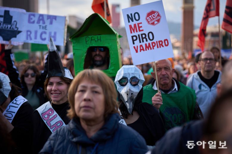 2025년 4월 5일 스페인 바르셀로나에서 높은 주택 임대비용에 항의하는 시위대의 모습. 팻말엔 “난 떠나지 않아, 뱀파이어야”라고 쓰여 있다. AP 뉴시스