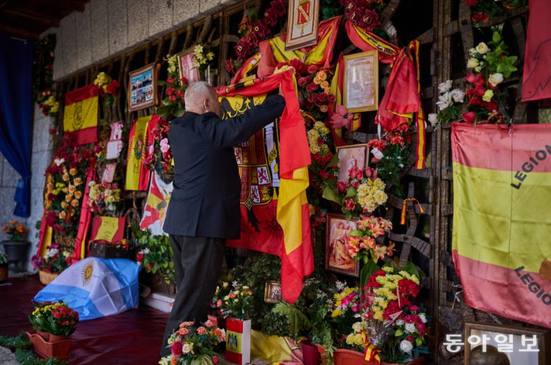 스페인 독재자 프란시스코 프랑코의 사망 50주년인 11월 20일, 한 남성이 마드리드 교외의 그의 묘소 앞에 헌법 제정 이전 스페인 국기를 걸고 있다. AP 뉴시스