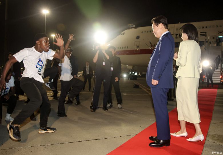 G20 정상회의에 참석하는 이재명 대통령과 김혜경 여사가 21일(현지 시간) 남아프리카공화국 요하네스버그 O.R. 탐보 국제공항에 도착해 공군1호기에서 내려 환영공연을 보고 있다. 요하네스버그=송은석 기자 silverstone@donga.com