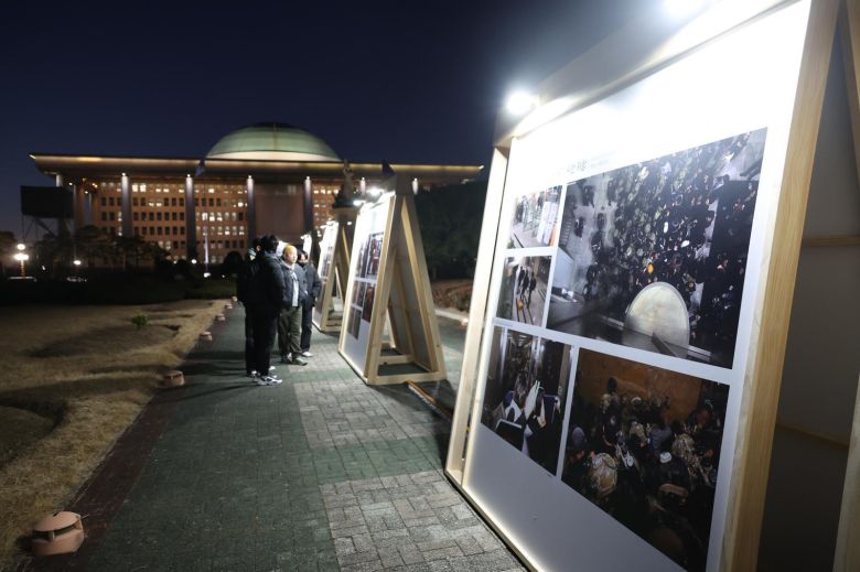 12·3 비상계엄 해제 1주년을 하루 앞둔 2일 서울 여의도 국회에서 시민들이 설치된 계엄 사진전을 보고 있다.2025.12.02. 뉴시스