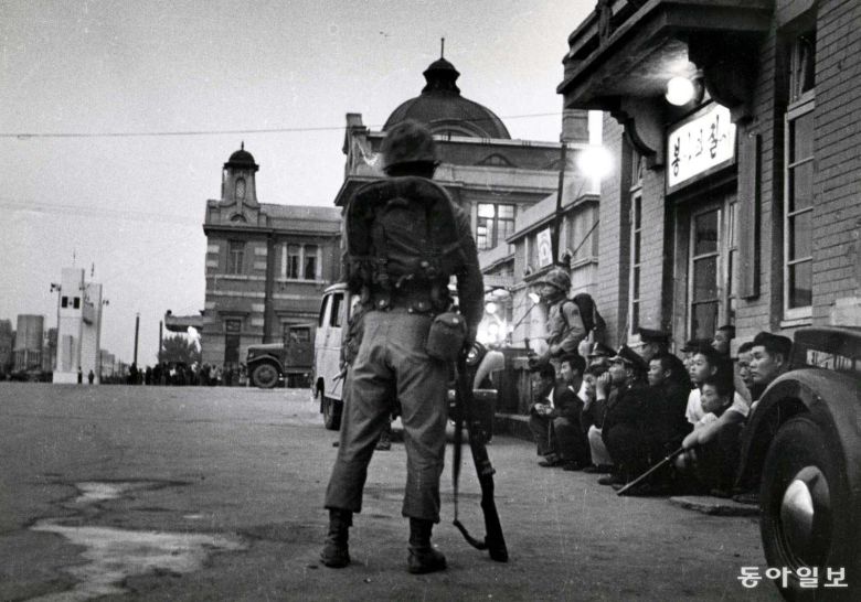 1961년5월16일 새벽 쿠데타를 일으킨 일단의 군인들이 서울역에서 행인들을 통제하고 있다. 시민들 사이에서 파출소 앞에 쪼그려앉은 경찰의 모습이 이채롭다. ＜이의택 촬영, 신동아 1984년 8월호＞/ 동아일보 DB
