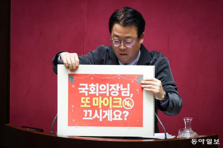 국민의힘 곽규택 의원이 11일 서울 여의도 국회에서 열린 본회의에서 ‘국회의장님 또 마이크 끄시게요’, ‘61년 만에 국회의장이 필리버스터 방해한 곳’ 등이 적힌 스케치북을 들고 무제한 토론하고 있다. 박형기 기자 oneshot@donga.com