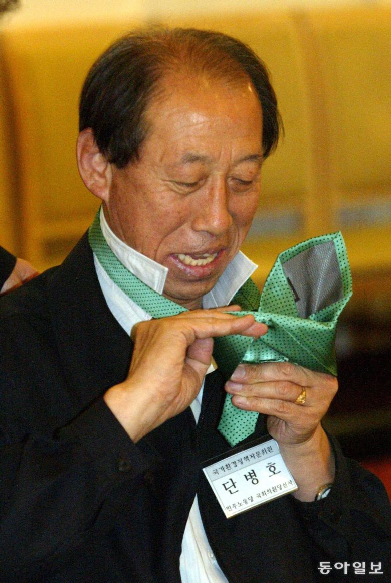 서울 세종문화회관 세종홀에서 열린 환경운동연합의 제3기 국가환경정책자문위원회 발족식에서 단병호 민주노동당 당선자가 증정받은 녹색넥타이를 매는 방법을 몰라 멋쩍은 웃음을 짓고 있다. 2004년 5월 2일. 동아일보 DB