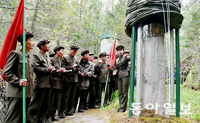 양강도로 답사 행군을 온 남성들이 구호나무 앞에서 여성 강사 설명을 듣고 있다. 동아일보 DB