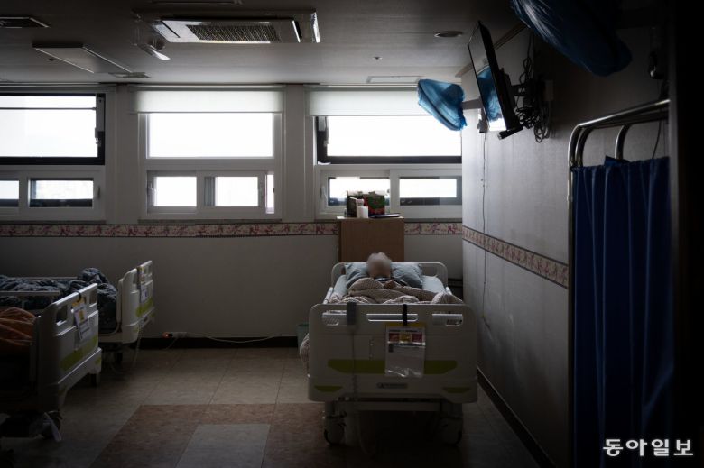 지난달 19일 불이 꺼진 요양원 방 안에 한 치매노인이 누워 잠을 청하고 있다.