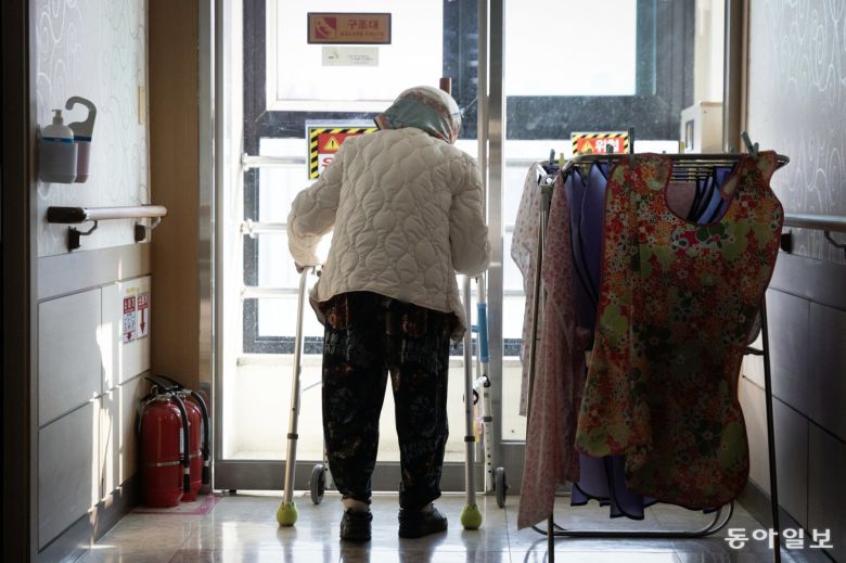 치매노인 김연순 씨가 보행보조기에 의지해 복도를 배회하고 있다.