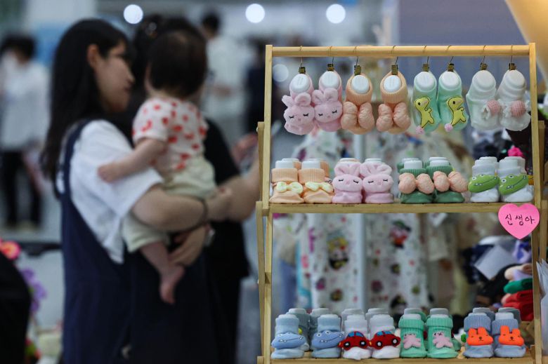 서울 강서구 코엑스 마곡에서 열린 한 베이비페어 행사에서 아이를 안은 여성이 육아용품을 둘러보고 있다. 뉴시스