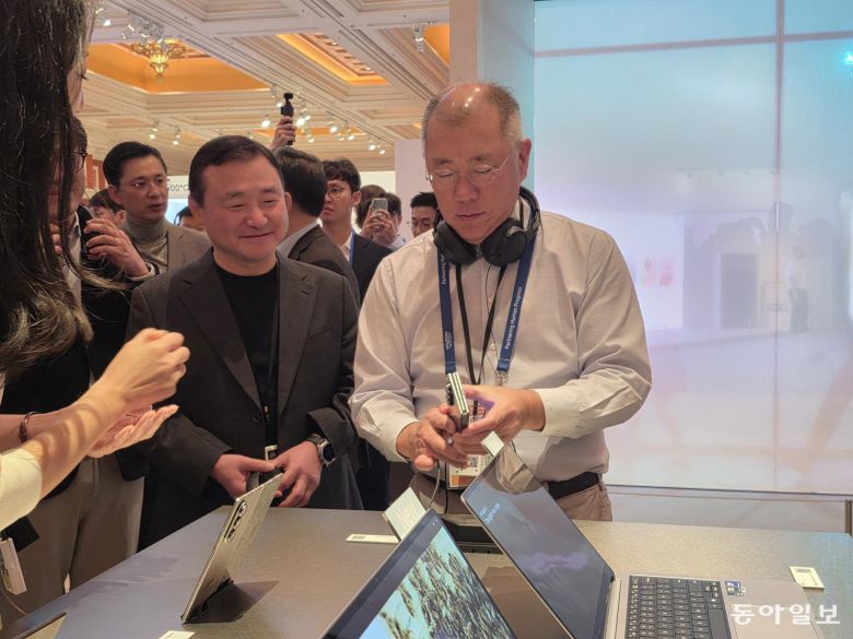 정의선 현대자동차그룹 회장(오른쪽)이 6일(현지시간) 미국 라스베이거스 윈 호텔에 있는 삼성전자 단독 행사장 ‘더 퍼스트룩’에서 삼성전자의 두번 접는 ‘갤럭시 Z 트라이폴드’를 만져보고 있다. 라스베이거스=이민아 기자 omg@donga.com