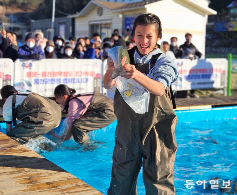 홍천강 꽁꽁축제가 9일 개막해 25일까지 열린다. 지난해 축제 때 송어 맨송잡기에 참가한 여성.  홍천군 제공