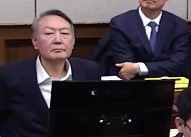 윤석열 전 대통령이 9일 서울 서초구 서울중앙지방법원에서 열린 내란 우두머리 혐의 1심 결심 공판에 출석해 자리에 앉아 있다. 2026.1.9 서울중앙지방법원 제공 영상 캡쳐