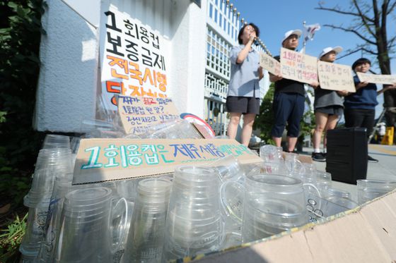 서울환경연합 관계자들이 7일 오전 정부서울청사 앞에서 일회용컵 보증금제 전국 시행 촉구 기자회견을 하고 있다. 〈사진=연합뉴스〉