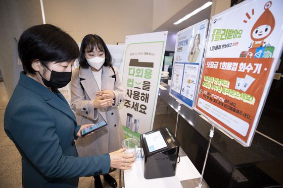 한화진 환경부 장관이 지난해 12월 7일 정부세종청사와 세종시 도담동에 마련된 일회용컵 회수기를 이용하고 일회용컵 보증금제 운영현황을 살피고 있다. 〈사진=연합뉴스〉