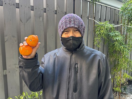 귤을 들고 환하게 웃어 보이는 전종준씨. 〈사진=김휘란 기자〉