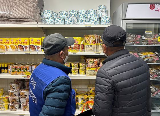 신중히 물건을 고르는 쪽방촌 주민. 〈사진=김휘란 기자〉