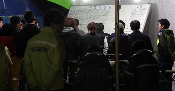 2014년 4월 진도 팽목항에서 가족들이 사망자 명단을 확인하고 있다. 〈사진=연합뉴스〉