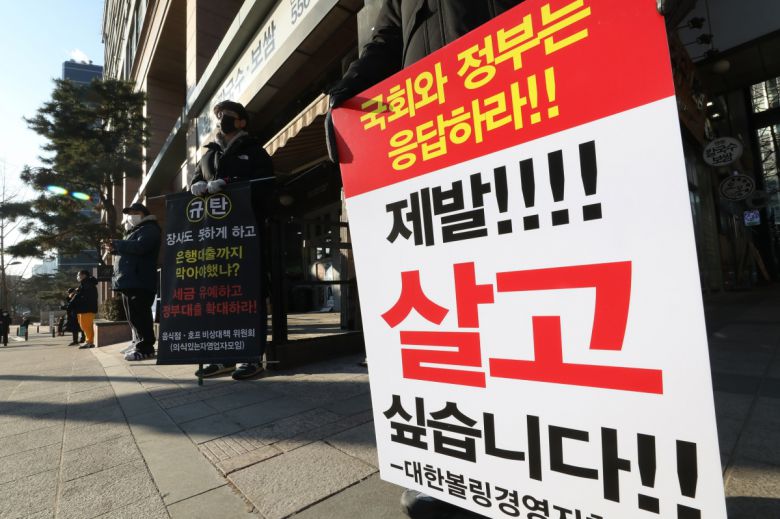 '사회적거리두기 단계 개편을 위한 공개토론회'가 열린 2일 오전 서울 중구 LW컨벤션에 마련된 토론회장 앞에서 자영업자들이 방역지침 끝장토론, 영업시간 연장 등을 촉구하는 1인 시위하고 있다.(뉴시스)
