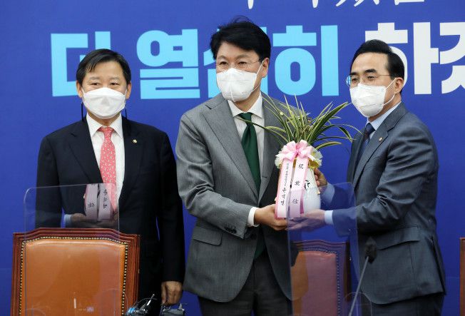 더불어민주당 박홍근 신임 원내대표(오른쪽)가 25일 서울 여의도 국회 원내대표 회의실에서 장제원 대통령 당선인 비서실장으로부터 윤석열 대통령 당선인의 축하 난을 받고 있다. 오른쪽부터 박홍근 신임 원내대표, 장제원 비서실장, 이철규 국민의힘 의원.