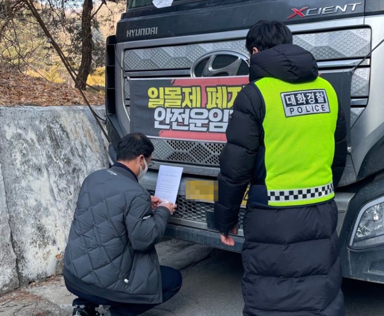 2일 오전 강원 영월군 한반도면 한일현대시멘트 앞에서 국토교통부와 영월군청 관계자들이 경찰 엄호 속에 화물연대 노조원 차량에 업무개시명령서를 붙이고 있다.