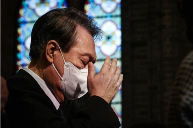 윤석열 대통령이 지난달 6일 서울 중구 명동성당에서 열린 이태원 참사 희생자 추모 미사에 참석해 성호를 긋고 있다.