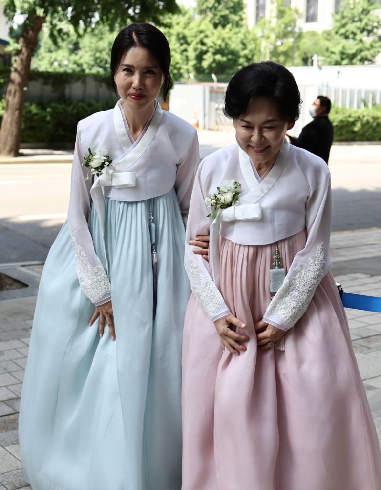 정몽원 HL그룹 회장의 부인 홍인화 씨(오른쪽)와 백지연 전 앵커가 2일 오후 서울 종로구 종교교회에서 열린 정 회장의 차녀 정지수 씨와 백 전 앵커의 외아들 강인찬 씨 결혼식에서 취재진을 향해 인사를 하고 있다. (연합뉴스)