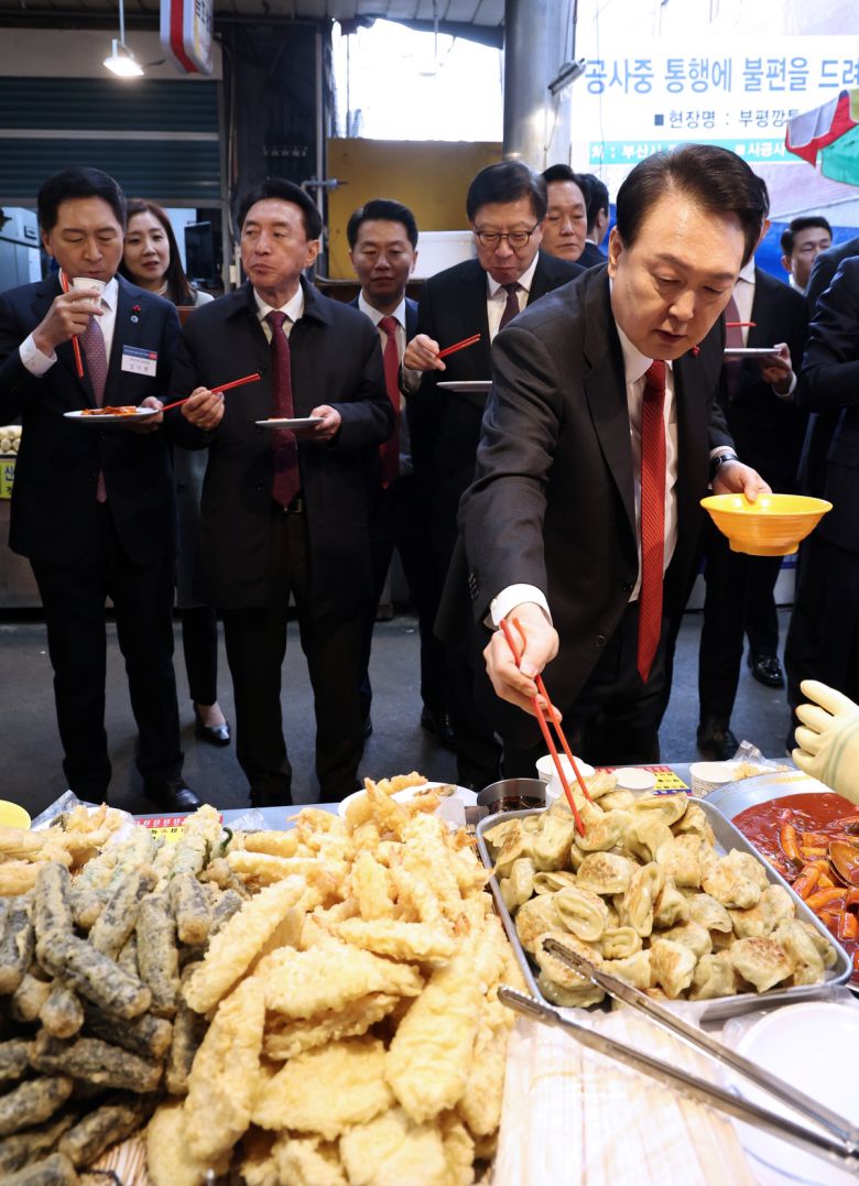 윤석열 대통령이 6일 부산 중구 깡통시장에서 만두 등 분식을 시식하고 있다. (연합뉴스)
