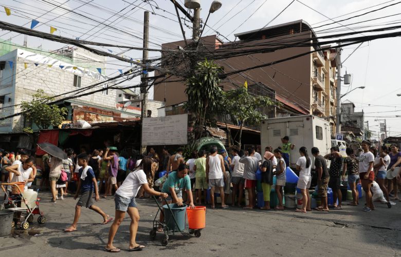 2019년 3월 13일 필리핀 마닐라 만달루용 거리에 엘니뇨 현상으로 물 부족 사태를 겪는 주민들이 물을 받기 위해 줄 서 있다.
