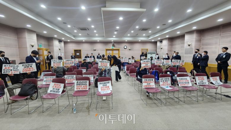 정기 주주총회에서 주주들이 피켓을 들고 항의하고 있다.