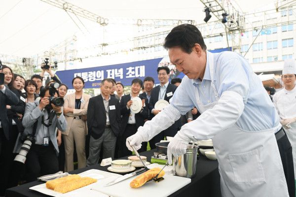 윤석열 대통령이 24일 서울 용산 대통령실 청사 잔디마당에서 열린 '대통령의 저녁 초대' 출입기자단 초청 만찬 간담회에서 계란말이를 만들고 있다.