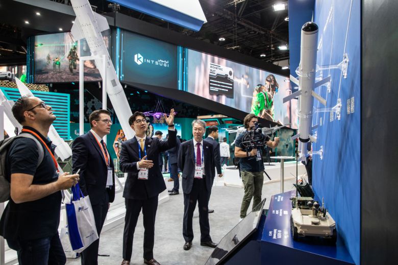 ‘IDEX 2023’ 전시장에 마련된 LIG넥스원 부스를 방문한 관람객들이 회사 관계자로부터 LIG넥스원의 현궁이 탑재된 현대로템 HR-SHERPA 무인차량(모형)에 대한 설명을 듣고 있다.