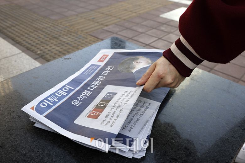 헌법재판소가 윤석열 전 대통령에 대한 파면을 선고한 4일 서울 여의도역 인근에서 시민이 이투데이가 발행한 호외를 챙기고 있다.