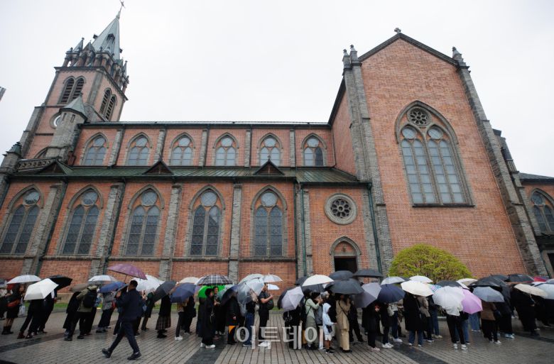 제266대 교황인 프란치스코 교황이 선종한 가운데 22일 서울 중구 서울대교구 주교좌 명동대성당에서 조문객들이 추모를 위해 길게 줄을 서서 대기하고 있다. 사진공동취재단
