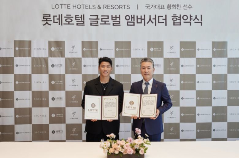 롯데호텔앤리조트 김태홍 대표이사(오른쪽)와 황희찬 선수가 글로벌앰버서더 협약식에서 포즈를 취하고 있다.