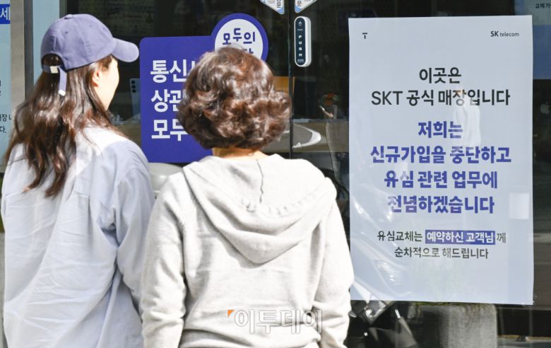 6일 서울 시내의 한 SK텔레콤 직영점에서 시민들이 신규 가입 업무 중단 안내문을 살펴보고 있다. SK텔레콤은 5일부터 유심(USIM) 정보 해킹 사고로 유심 교체를 원하는 기존 가입자부터 우선적으로 교체하기 위해 전국 T월드 매장과 온라인에서 신규 가입 업무를 중단했다. 조현호 기자 hyunho@