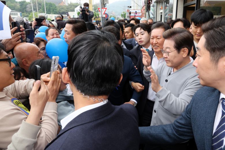 민심을 청취하는 '경청 투어'에 나선 이재명 더불어민주당 대선후보가 11일 전남 화순군 화순읍 인근 거리에서 경호를 받으며 주민들에게 인사하고 있다.