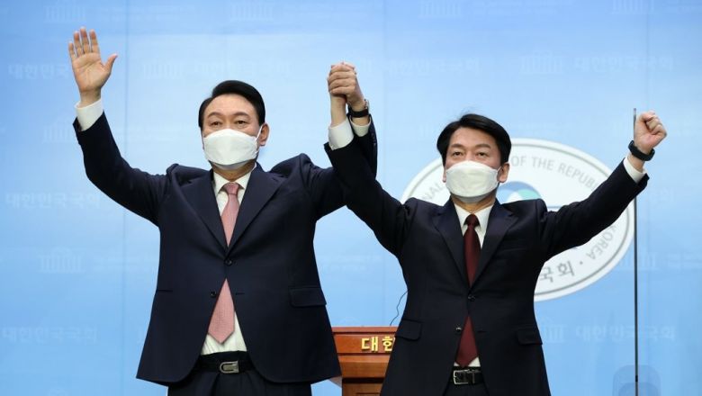 2022년 3월 윤석열 국민의힘 후보와 안철수 국민의당 후보가 국회 소통관에서 단일화 기자회견을 마치며 포즈를 취하고 있다.