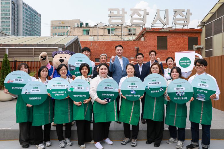 29일 서울 종로구 광장시장 앞에서 초록색 앞치마를 착용한 직원들과 정장을 입은 관계자들이 단체로 포즈를 취하며 매장 오픈 기념 행사를 진행하고 있다.