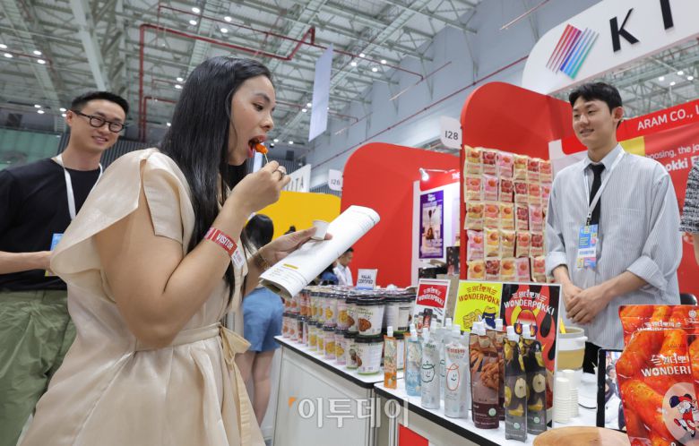 5일 베트남 호치민 SECC전시장에서 한국무역협회 주관 코엑스 주최로 열린 2025 베트남 국제 프리미엄 소비재전(VIPREMIUM)을 찾은 한 바이어가 떡볶이를 시식하고 있다. 올해 전시회는 8일 까지 뷰티, 패션, 리빙, 식품 등 다양한 소비재분야의 200여개 국내외 기업이 참가해 프리미엄 제품과 최신 라이프스타일을 선보인다. /2025.06.05./호치민=사진공동취재단