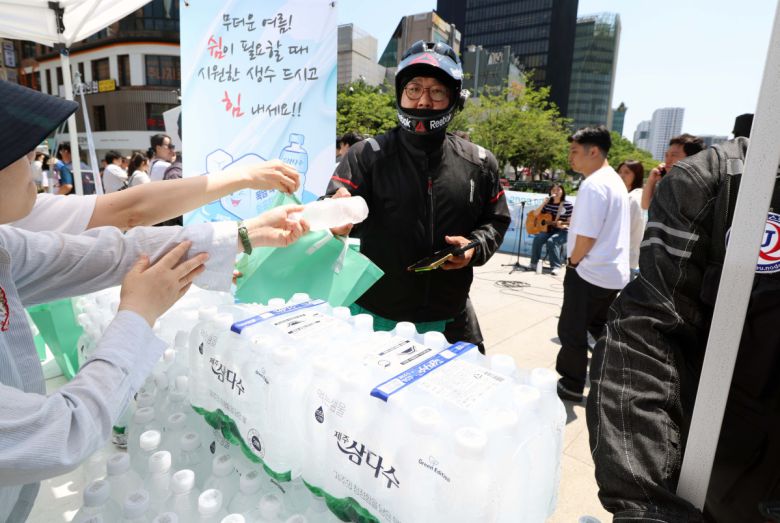 11일 서울 종로구 청계천 장통교에서 열린 ‘2025 이동노동자 생수나눔 공동 캠페인’에서 관계자들이 이동노동자에게 시원한 생수를 제공하고 있다. 이번 캠페인은 본격적인 혹서기를 앞두고 야외에서 일하는 이동노동자의 온열질환 예방을 위해 마련됐으며, 이날부터 서울 시내 31개 노동센터, 쉼터에서 제주삼다수 10만병을 수령할 수 있다. 신태현 기자 holjjak@