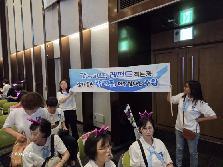 수원특례시 광교1동 봉사자들이 13일 수원컨벤션센터에서 열린 ‘2025 새빛 힐링콘서트’ 행사장에서 응원현수막을 들고 힐링콘서트를 즐겼다 .