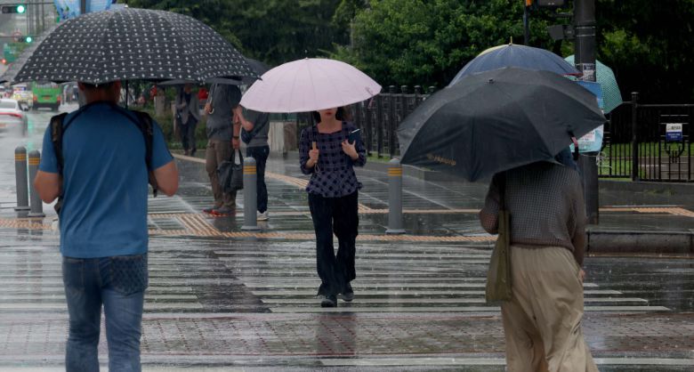 본격적인 장마가 시작, 서울에 호우주의보가 경기·인천에 호우경보가 발령된 20일 서울 세종대로사거리에서 우산을 쓴 시민들이 발걸음을 옮기고 있다. 신태현 기자 holjjak@